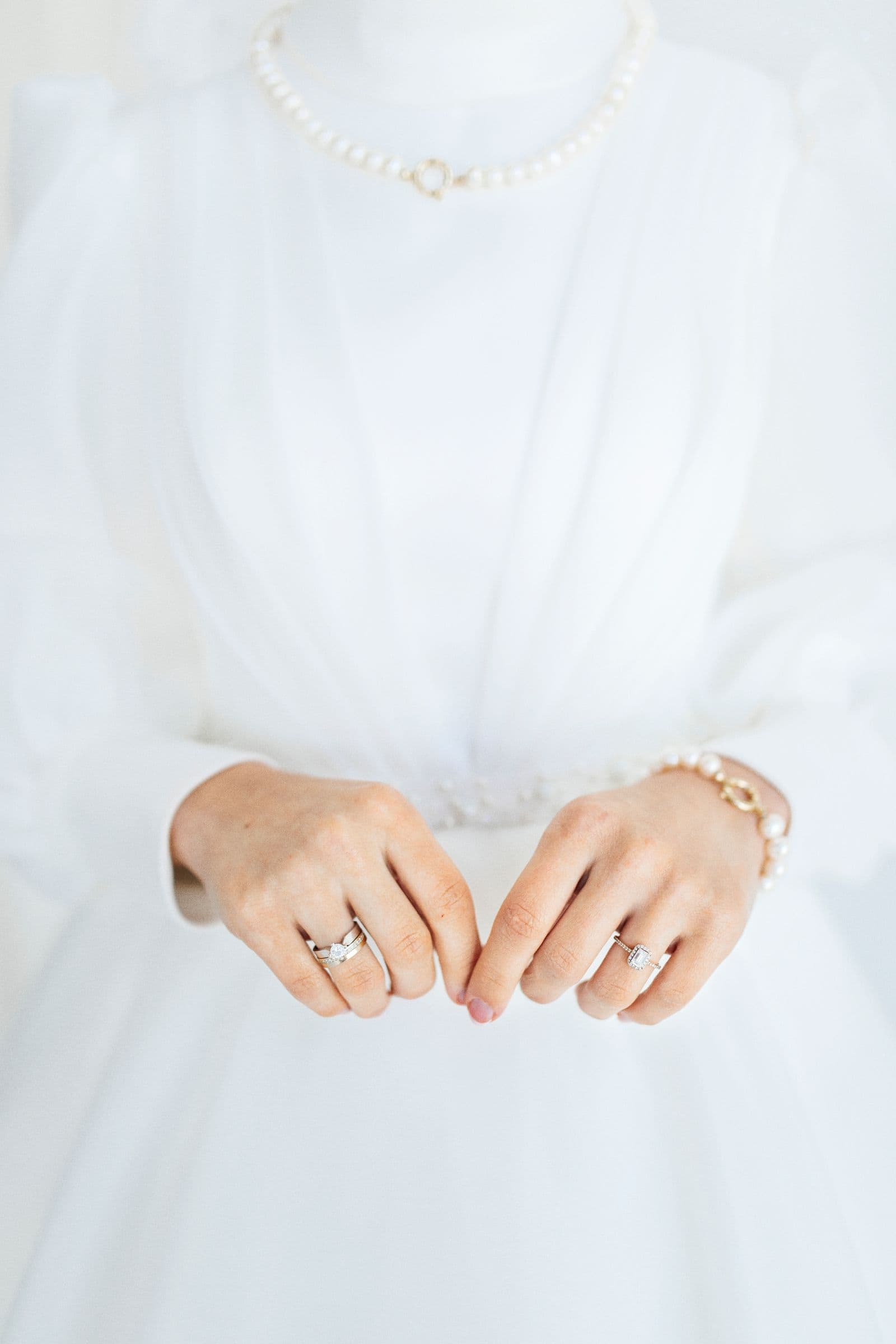 A bride's hands, adorned with pearl jewellery